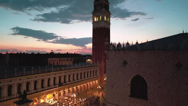 Aerial view of san Marco square bell tower at night. Drone flying on Piazza San Marco. St Mark Square in Venice, Italy. Basilica Campanile in Venice. Piazza San Marco featuring Doges Palace.