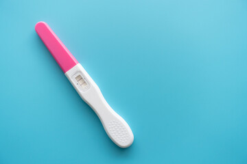 White Plastic Pregnancy test positive with two stripes results isolated on Pastel light blue...