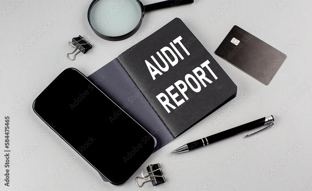 Poster audit report text written on black notebook with smartphone, magnifier and credit card