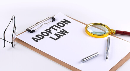 ADOPTION LAW text on clipboard on white background, business concept