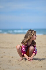 Fototapeta premium A child plays with sand on the beach 
