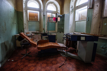 Old broken dentist chair in abandoned dental clinic