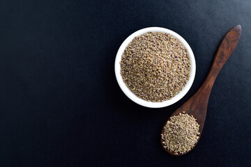 Top view of ajwain on bowl and spoon on dark background