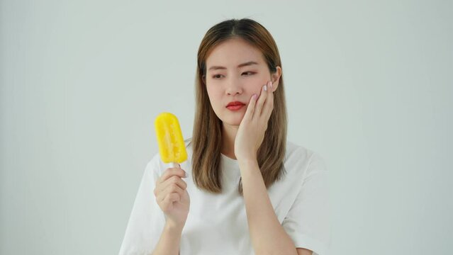Asian woman feel sensitive teeth after eating ice cream, female suffer tooth, decay problems, dental care, tooth extraction, decay problem, bad breath, Gingival Recession, Oral Hygiene instruction