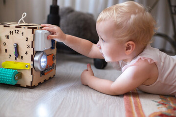 Activity Board. The baby learns the numbers on the clock on the bisiboard. Early development of...
