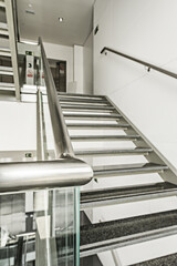 Stainless steel stairs, tempered glass and polished black granite steps in an office building