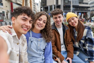 Friends taking selfie on a bench in Spain.