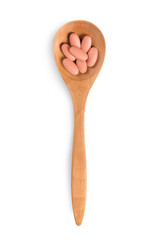 Top view of supplement dietaries on wooden spoon on white 