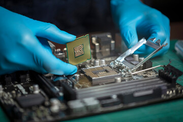 Technician or repairman in gloves holding hands CPU microprocessor to motherboard socket in...