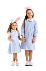 Little girls in bunny ears on white background. Easter celebration