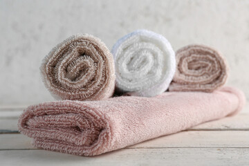 Fototapeta na wymiar Rolled soft towels on wooden table
