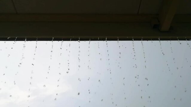 Rain is dropping on the roof, Heavy rain drop down on eaves in raining day.