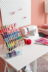 Tailor's workplace with thread spools and sewing machine in atelier