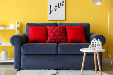 Interior of living room with red pillows on blue sofa