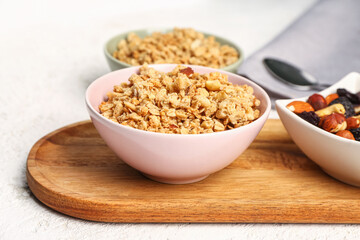 Bowls of tasty granola on light background