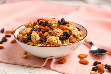 Bowl of tasty granola on light background, closeup