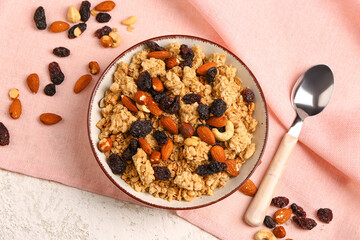Bowl of tasty granola on light background