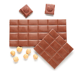 Tasty chocolate and hazelnuts on white background