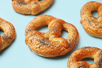 Tasty pretzels with poppy seeds on color background, closeup