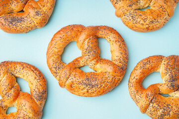 Tasty pretzels with poppy seeds on color background, closeup