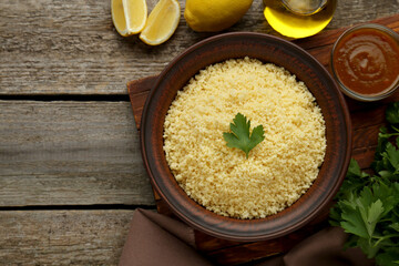 Tasty couscous and ingredients on wooden table, flat lay. Space for text