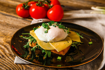 Plate with tasty egg Benedict on wooden background