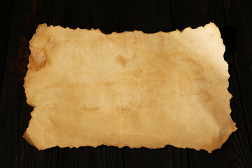 Sheet of old parchment paper on wooden table, above view