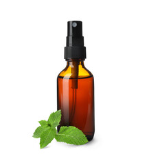 Bottle of mint essential oil and green leaves on white background