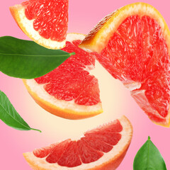 Cut fresh grapefruit and green leaves flying on pink background