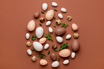 Creative composition with Easter eggs and plant leaves on brown background