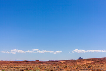 Low horizon photo of the edge of Monument Valley with red rocks and blue sky