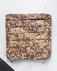 Top view of chocolate fudge with nuts on a marble board, chocolate fudge cut into pieces, fudge candy on a chopping board