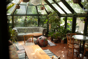 Modern Minimalism Interior Concept with a wooden floor, sofa, bean bag, table and chair. It's a little bit tropical plant