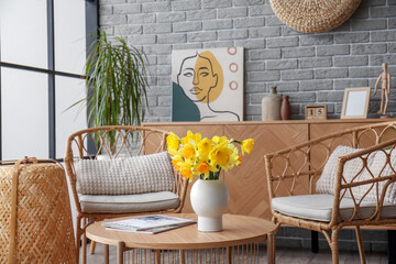 Interior of stylish living room with cozy armchairs and flower vase on coffee table