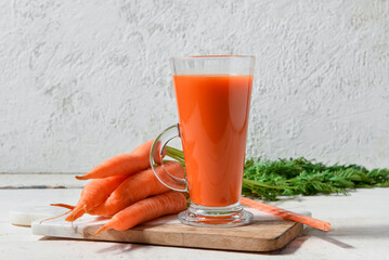 Fototapeta Glass of fresh carrot juice on white grunge table obraz