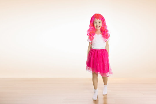 Portrait of cute little girl with pink hair. Little girl smiling at camera.