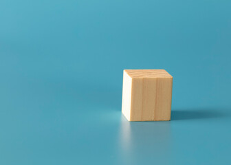 Geometric wood cube shape on blue background. 