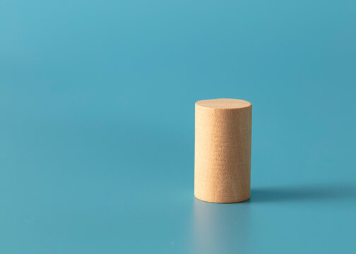 Geometric wood cylinder shape on blue background. 