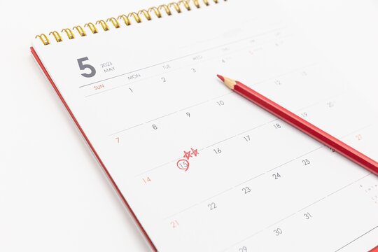 There is a calendar with a white background and a red pencil on a white background. A colored pencil in red marks the May 15th of the calendar. May 15th is Teacher's Day in Korea, Asia.