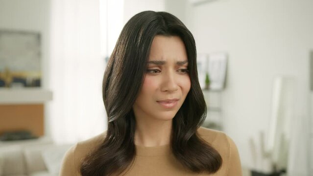 Closeup upset girl looking at camera. Portrait of sad woman face. Female model posing indoors looking with question in camera - why you betrayed me, how can you do it. Sadness concept in slow motion