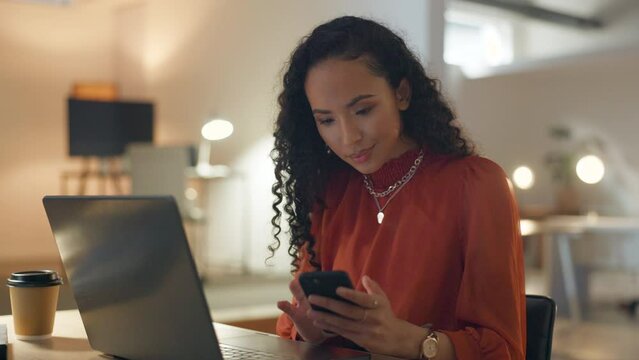 Business woman, night writing and phone scroll of mixed race female at a office. Employee, work communication and professional networking on a website app with a smile at a company with technology
