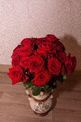 A lovely beautiful bouquet of scarlet roses in a vase. Flowers.