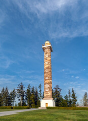 Astoria Column in Oregon with bright blue sky and wispy white clouds on a beautiful sunny afternoon.