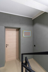 A staircase of tiles in a new house. Metal black railing, entrance to the apartment