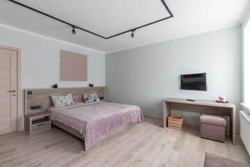 Hotel room with a large double bed in light colors