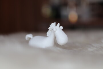 Fototapeta na wymiar 3d printed white unicorn on white fur