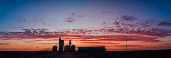 Panoramic view of silo silhouettes against the dawn colours.