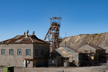 Fototapeta na wymiar Headframe and buildings at old mining site in Broken Hill, NSW, Australia. This area of Broken Hill is where the mining company BHP was founded in 1885. They mined silver, lead and zinc.