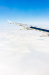 View from the airplane window at a beautiful cloudy sky and the airplane wing