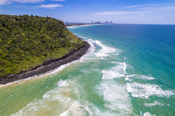 City coming into view as the drone flies around the headland in the Gold Coast